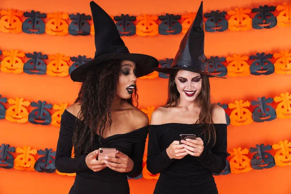 Imagen de mujeres brujas en traje de halloween negro mirando a la celda —  Fotos de Stock