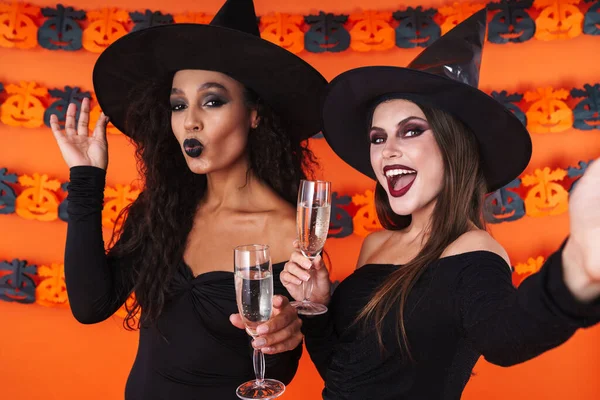 Imagen de mujeres brujas en traje de halloween sosteniendo copas de champán —  Fotos de Stock