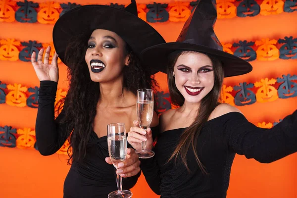 Imagen de mujeres brujas en traje de halloween sosteniendo copas de champán —  Fotos de Stock