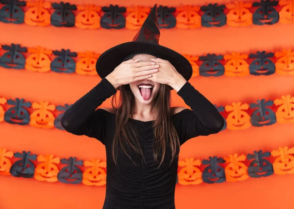 Immagine di divertente strega ragazza in costume nero di Halloween che copre lui — Foto Stock