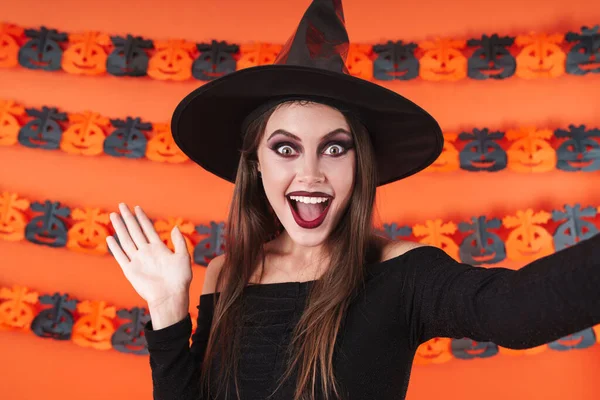 Imagem da bruxa menina em traje preto halloween sorrindo e acenando — Fotografia de Stock