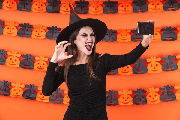 Imagen de chica bruja en traje de halloween negro tomando selfie —  Fotos de Stock