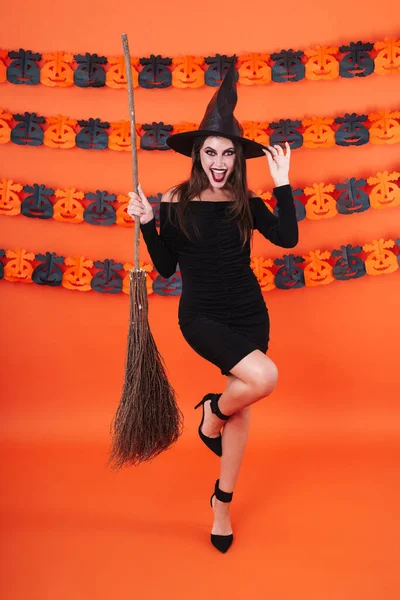 Imagem da bela bruxa menina em preto halloween fantasia segurando — Fotografia de Stock
