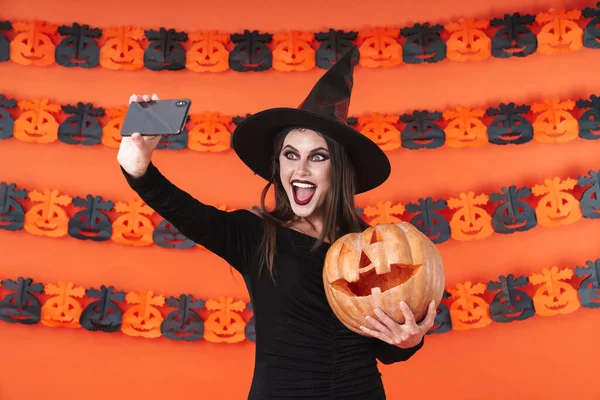 Imagen de chica bruja en traje de Halloween tomando selfie con bomba —  Fotos de Stock