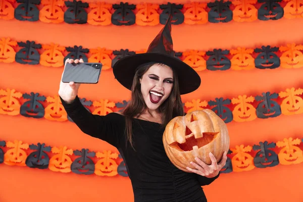 Imagem da bruxa em traje de Halloween tomando selfie com bomba — Fotografia de Stock