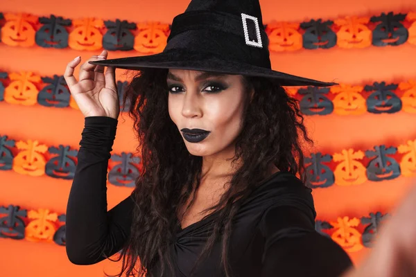 Imagen de chica bruja en traje de halloween negro tomando selfie pho —  Fotos de Stock