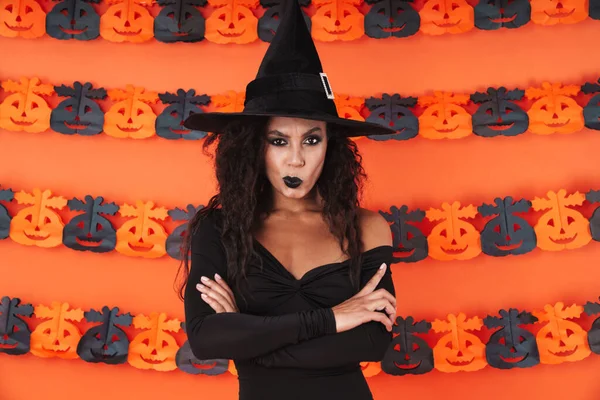 Изображение ведьмы в костюме на Хэллоуин, стоящей с воронами на руках — стоковое фото