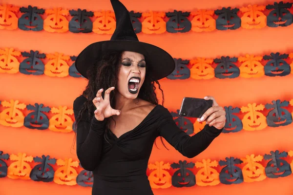 Imagen de chica bruja en traje de halloween gritando mientras toma —  Fotos de Stock