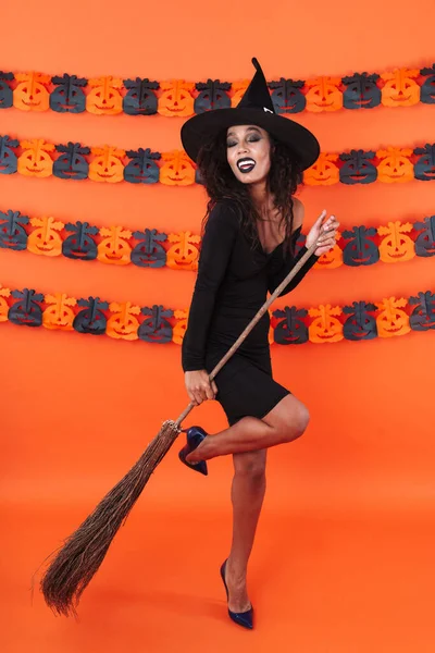 Imagem de menina bruxa atraente em preto halloween fantasia holdin — Fotografia de Stock