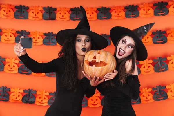 Imagen de mujeres brujas en traje de halloween tomando selfie con pum —  Fotos de Stock