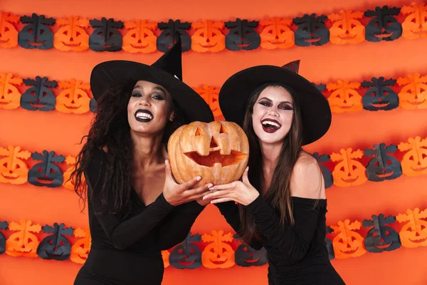 Imagen de mujeres brujas felices en traje de halloween negro sosteniendo la PU —  Fotos de Stock