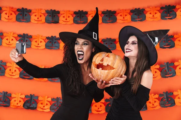 Imagen de mujeres brujas en traje de halloween tomando selfie con pum —  Fotos de Stock