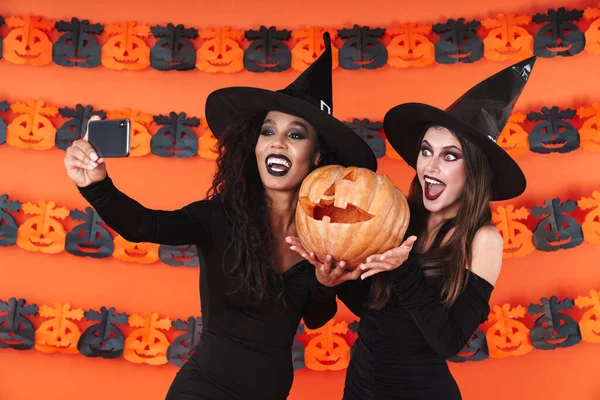 Imagen de mujeres brujas en traje de halloween tomando selfie con pum —  Fotos de Stock