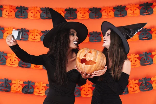 Bild av häxa kvinnor i halloween kostym tar selfie med Pum — Stockfoto