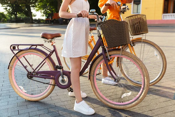 Duas meninas muito felizes usando vestidos de verão andar de bicicleta — Fotografia de Stock
