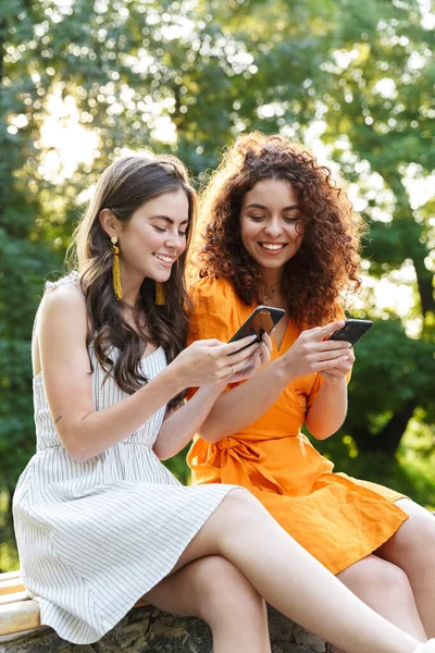 Twee vrolijke jonge meisjes vrienden die tijd buiten doorbrengen — Stockfoto