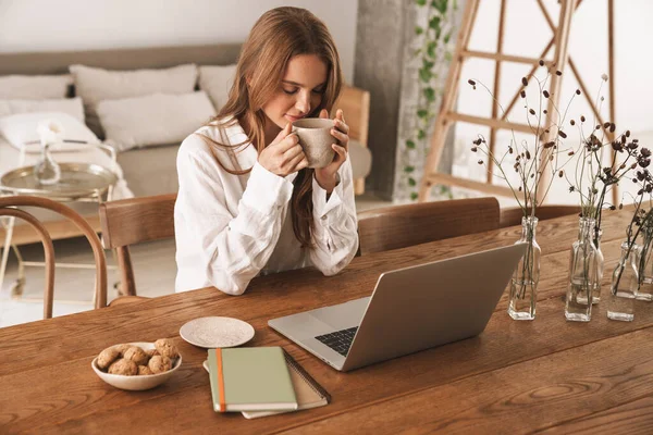 Jengibre mujer de negocios sentarse en el interior en la oficina beber café . — Foto de Stock