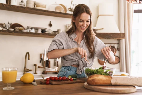 Gelukkig positief schattig mooi vrouw binnen in de keuken koken. — Stockfoto