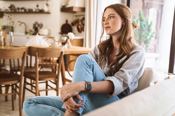 Rothaarige Frau sitzt zu Hause in der Küche. — Stockfoto