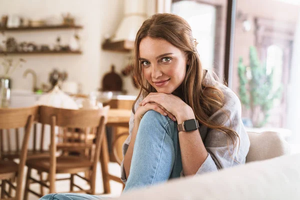 Pelirroja mujer en el interior sentada en la cocina en casa . — Foto de Stock