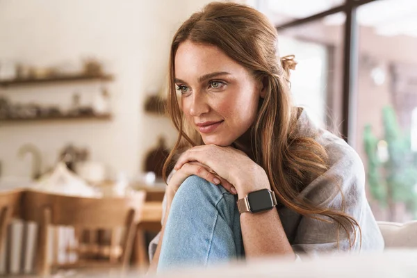 Rothaarige Frau sitzt zu Hause in der Küche. — Stockfoto