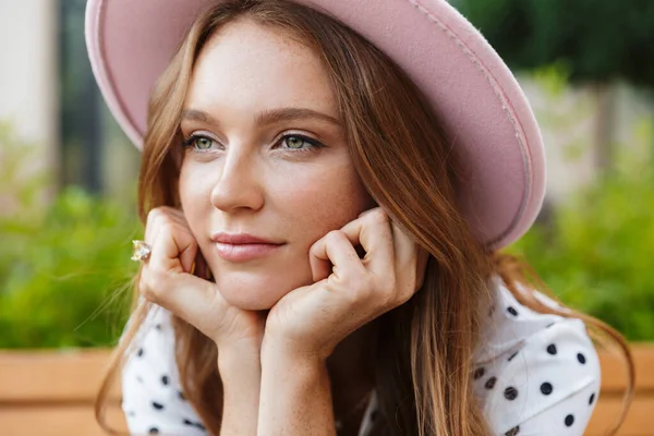 Redhead woman sit on a bench outdoors at the street — Stock Photo, Image