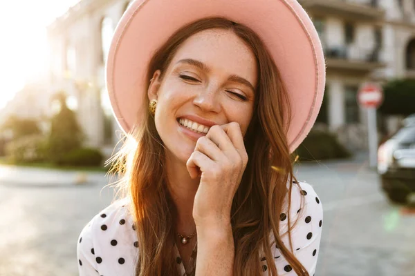 Redhead woman walking by street outdoors in dress and hat. — Stock Photo, Image