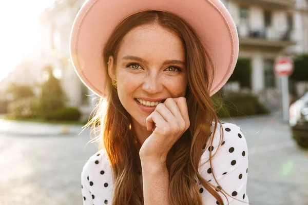 Donna rossa che cammina per strada all'aperto in abito e cappello . — Foto Stock