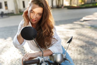 Yazlık kıyafetler giyen güzel bir genç kız.