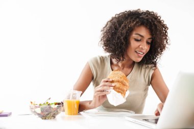Masada oturan güzel, genç bir Afrikalı kadın.