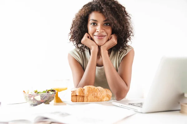 Beautiful young african woman sitting at the desk — Stock Photo, Image