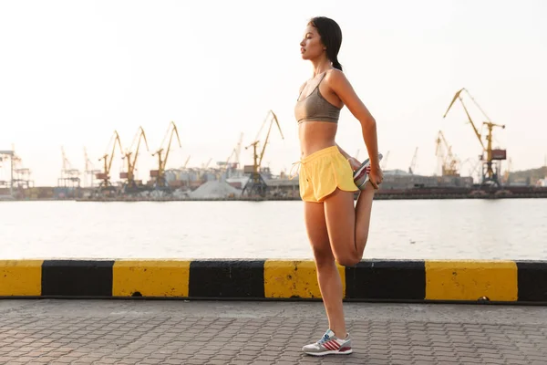 Imagen de una joven asiática haciendo ejercicio contra el puerto marítimo — Foto de Stock
