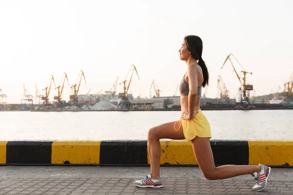 Image de femme asiatique heureuse faisant de l'entraînement contre le port de la mer — Photo