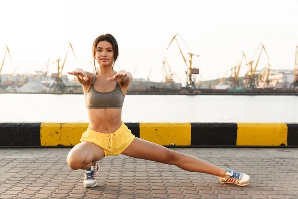 Imagen de fitness mujer asiática haciendo ejercicio contra el puerto marítimo — Foto de Stock