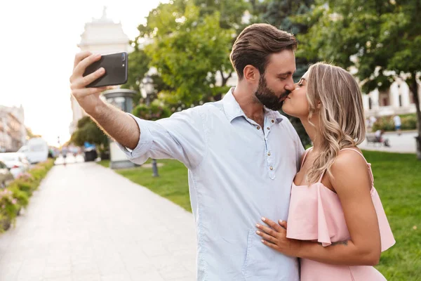 Pareja caminando por la calle al aire libre tomar una selfie por teléfono móvil . — Foto de Stock