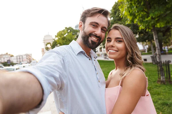 Coppia passeggiando per strada all'aperto prendere un selfie dalla fotocamera . — Foto Stock