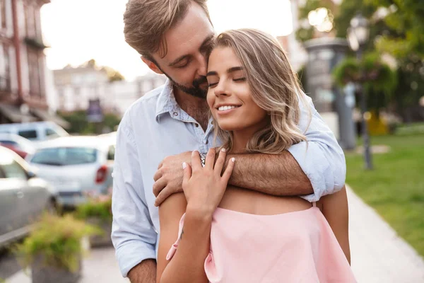 Loving couple walking by street outdoors hugging — ストック写真