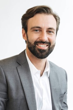 Ofiste çalışırken gülümseyen ve yan bakan mutlu iş adamının resmi.