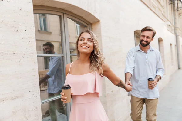Unga kärleksfulla par utomhus promenader dricka kaffe. — Stockfoto