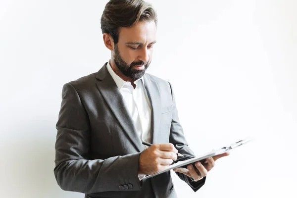 Kép a komoly koncentrált üzletemberről, aki irodai munka közben dokumentumokat olvas és jegyzeteket ír — Stock Fotó