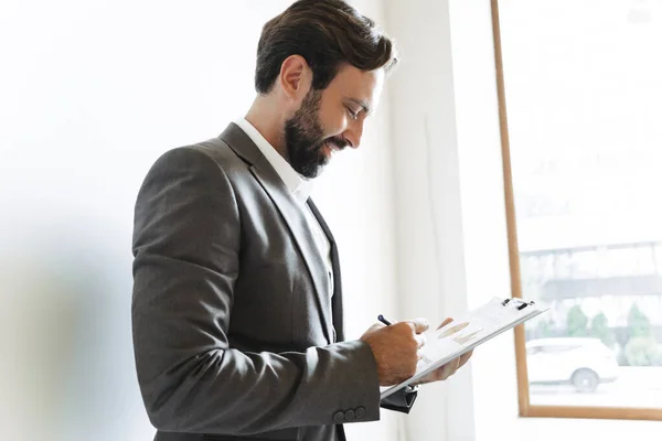 Immagine di un uomo d'affari di successo che tiene appunti e annota mentre lavora in ufficio — Foto Stock