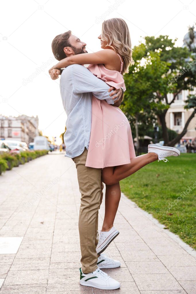 Loving couple walking by street outdoors hugging