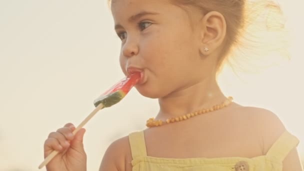 Happy Pretty Child Eating Lollipop Enjoys Park Outdoors — Stock Video