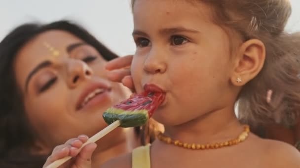 Gülümseyen Hintli Kadının Yakın Görüntüsü Mutlu Kızıyla Dışarıda Lolipop Yiyen — Stok video