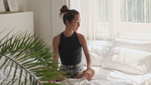 Feliz Bonita Mulher Asiática Olhando Redor Enquanto Sentado Cama Casa — Vídeo de Stock