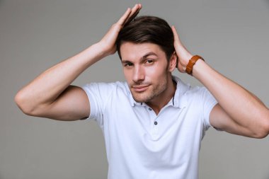 Genç adam gri duvar arka planında izole poz veriyor