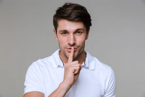 Jongeman poseren geïsoleerd over grijze muur — Stockfoto