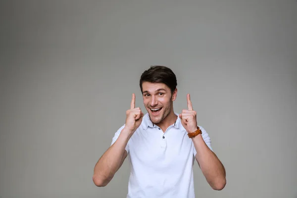 Joven guapo positivo señalando a un lado . — Foto de Stock