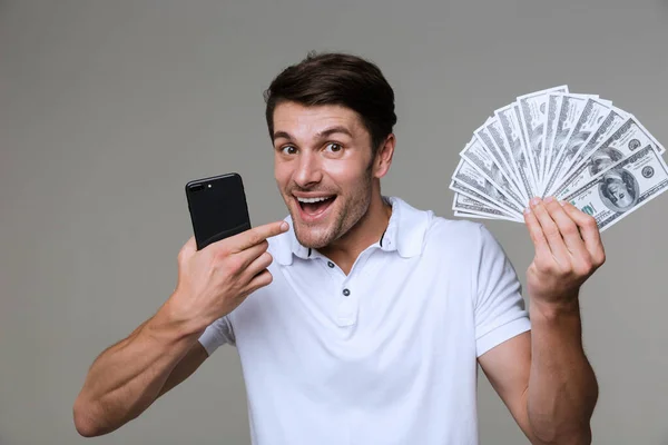 Positive young man holding money. — Stock Photo, Image