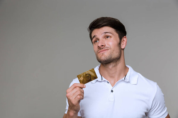 Мыслящий человек держит дебетовую карту
.